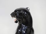 a black bear statue sitting on a white surface