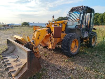 un tracteur jaune garé dans l'herbe