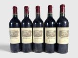 six bottles of wine are lined up in a row on a white surface