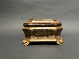 an antique brass box with a lid on a grey background