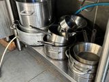 many pots and pans on the shelf in the kitchen