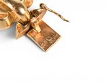 a gold plated object on a white surface