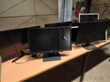 three computer monitors sitting on a table in a room