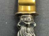 a silver knife with a gold handle on a table