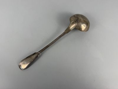 silver spoon with a long handle on a white surface
