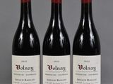 trois bouteilles de vin rouge posées sur une table