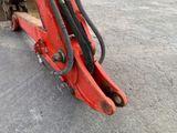 a red excavator that is sitting on the ground