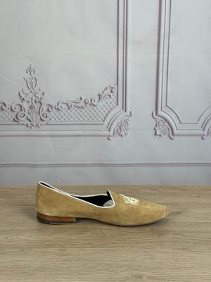yellow shoes on a wooden table in front of a white wall