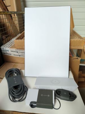 une boîte blanche avec, à côté, un cordon d'alimentation et un chargeur