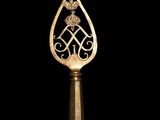 a gold spoon with an ornate design on it on a black background