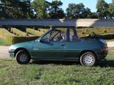 a green car that is parked in the grass