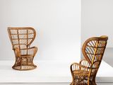 pair of wicker chairs in a white room with a white backdrop