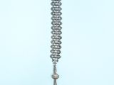 a silver necklace with a bell hanging from it ' s side