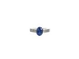 un gros plan d'une bague sertie d'une pierre bleue sur fond blanc