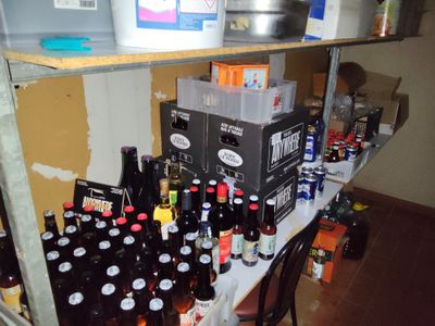 de nombreuses bouteilles de bière sur une étagère dans une pièce