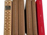 four books are lined up in a row on a white surface