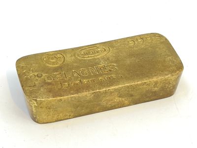 un vieux lingot d'or posé sur une surface blanche, avec un fond blanc