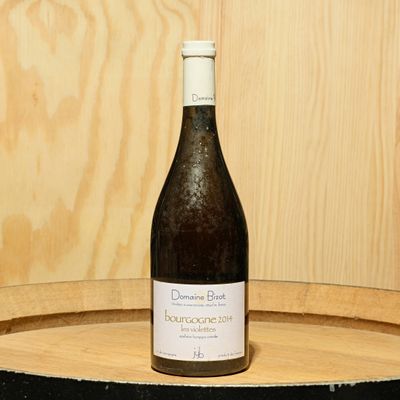 une bouteille de vin posée sur un tonneau