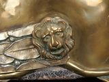a bronze sculpture of a lion head on a black surface