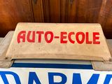 a sign on a bed with a wooden headboard in the background