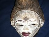 an old wooden mask on a blue cloth with a black background