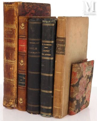 several old books are stacked on top of each other on a table