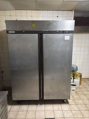 réfrigérateur à double porte en acier inoxydable dans une cuisine professionnelle dotée d'un carrelage au sol
