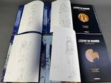 three books with drawings of people on them sitting on a table