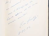an open book with a handwritten note on it sitting on a table