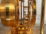 a gold clock inside of a glass case