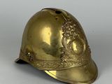 un vieux casque en laiton orné d'un motif floral sur le côté