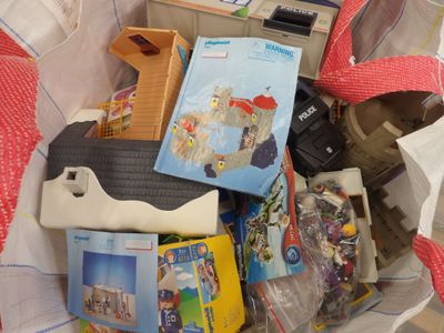 un tas de jouets dans un sac posé par terre