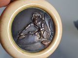 a person holding a silver medal in their hand