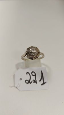 gros plan d'une bague sur une surface blanche avec une étiquette de prix