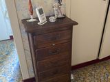 a small chest of drawers in the corner of a room