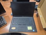 a laptop computer sitting on a desk in front of a computer monitor