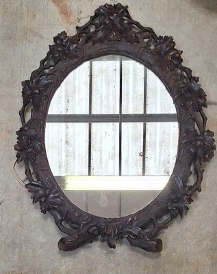un miroir rond accroché au mur à côté d'une fenêtre