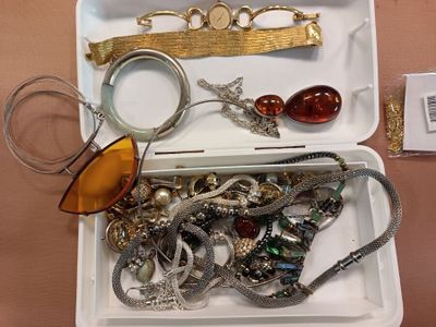 a tray of jewelry and a pair of glasses on a table