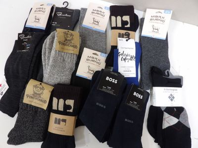 Plusieurs paires de chaussettes pour homme sont posées sur une surface blanche