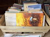 de nombreux livres dans une caisse en bois posée par terre