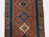 un vieux tapis présentant un motif géométrique sur fond blanc