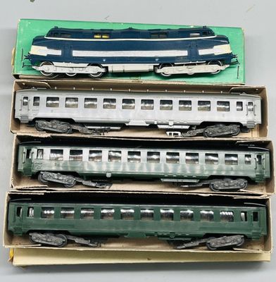 trois boîtes de petits trains posées sur une table blanche