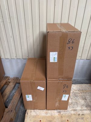 three boxes are stacked on a pallet in front of a building