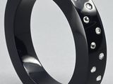 un gros plan d'une bague noire parsemée de points argentés