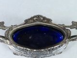 a silver plate with a blue glass in it