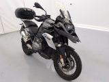 une moto noire et blanche garée dans une pièce blanche