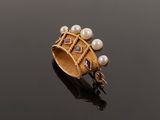 an antique gold ring with pearls and garnets on a black surface