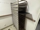 a person holding a cigarette in front of a rack of trays