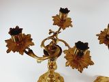 a gold candle holder with three flowers on it