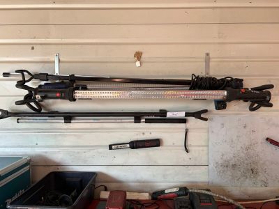 several tools are hanging on a wall in a garage